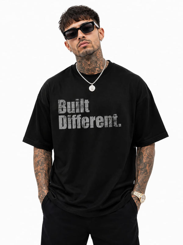 KLYRO FASHION black oversized crewneck t-shirt with distressed Built Different graphic print worn by a male model