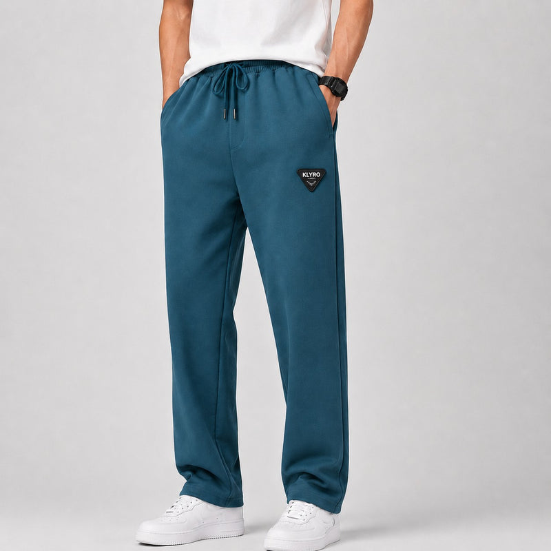 KLYRO FASHION men's relaxed fit track pants in deep teal with an adjustable drawstring waist and branded patch detail.